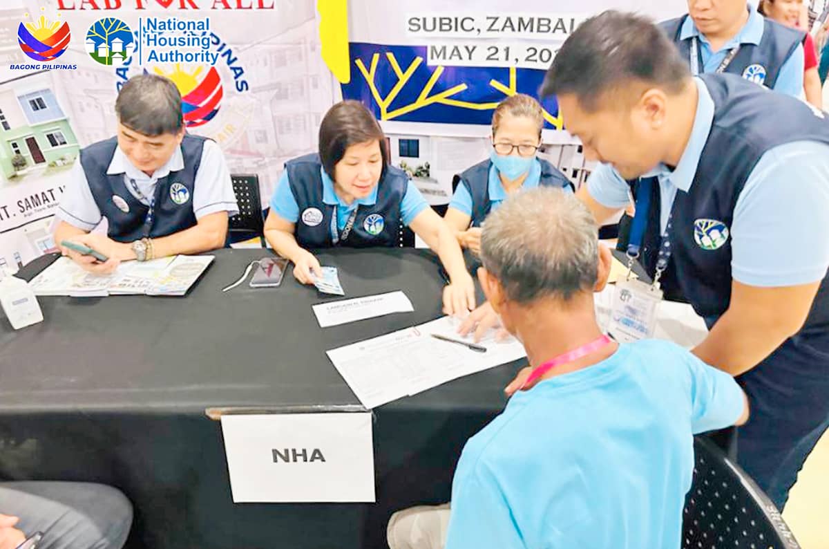 STAFF of National Housing Authority assist a beneficiary of an emergency housing assistance.
